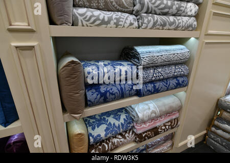 Many blankets and decorative pillows on shop window Stock Photo