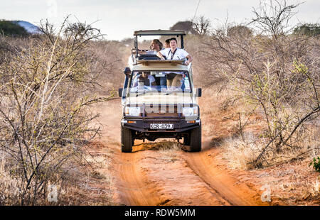 TSAVO EAST RESERVE, KENYA - OCTOBER 11, 2018: Safari cars with unindentified tourists on adventure trip in Tsavo East National Park, Kenya Stock Photo