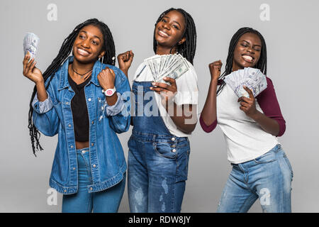 Photo of lovely african girls holding money dollar bills and smiling on camera over white background Stock Photo