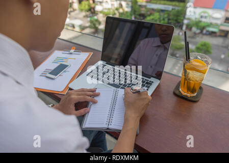 Young Asian businessman writing notes Stock Photo