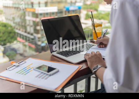 Asian freelancer writing notes outdoor Stock Photo