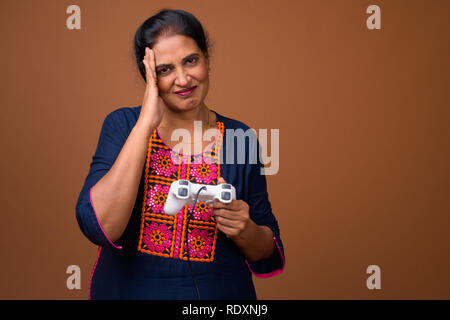 Indian woman playing video games using game controller Stock Photo