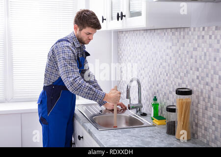 Man Using a Plunger to unstop his bathroom sink 4817267 Stock Photo at  Vecteezy