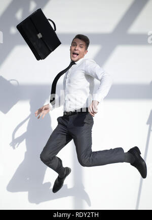 business man jumping in the air with a large smile on his face Stock Photo