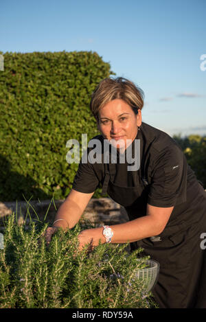 Head chef Jacqueline Smith (model released) harvesting herbs in the Coopers Residence garden at the Landing. The Landing is a luxury private property  Stock Photo