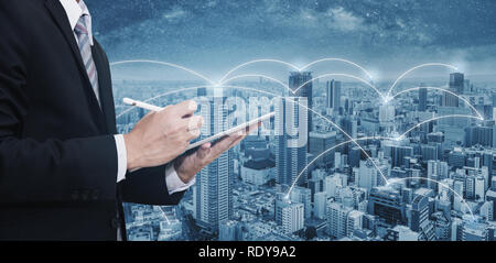 Double exposure businessman using digital tablet, and cityscape. Business network, blockchain technology and internet connection Stock Photo