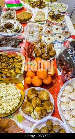 Rich table spread with many different dishes, fruits and deserts. Stock Photo