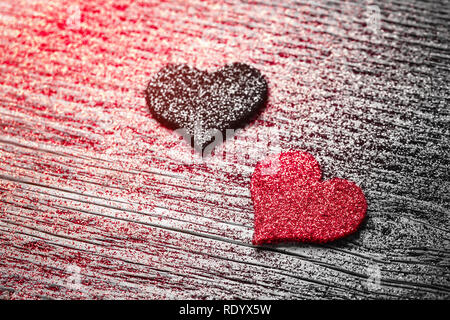 Red and black felt hearts on glittering wooden background Stock Photo