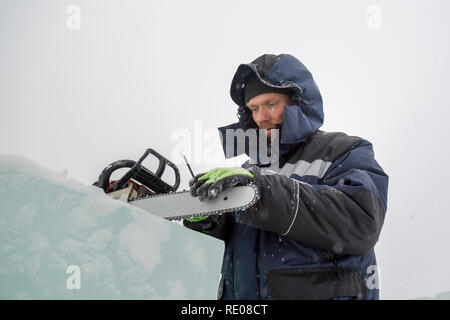 A manual file worker sharpens a chainsaw chain Stock Photo
