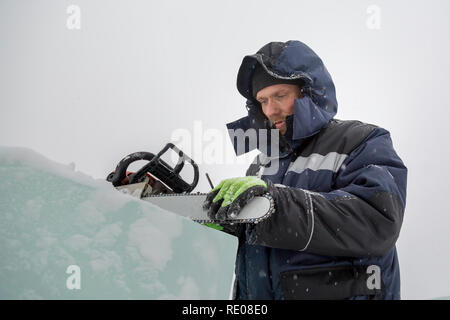 A manual file worker sharpens a chainsaw chain Stock Photo