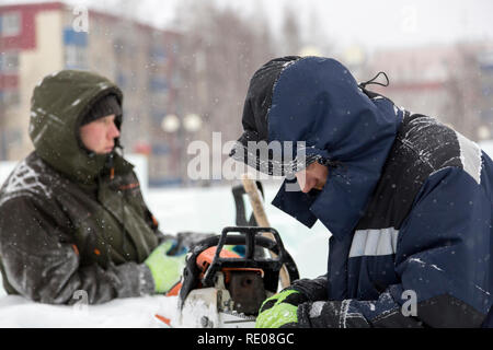 A manual file worker sharpens a chainsaw chain Stock Photo
