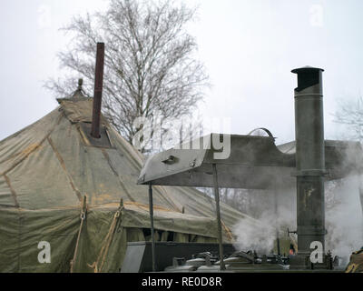 a military cook prepares dinner for the soldiers in winter. camp kitchen and tent. russian style. Stock Photo