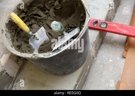 A plastic construction bucket with cement based glue ready to be used for gluing ceramic tiles. Stock Photo
