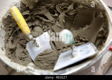 A plastic construction bucket with cement based glue ready to be used for gluing ceramic tiles. Stock Photo