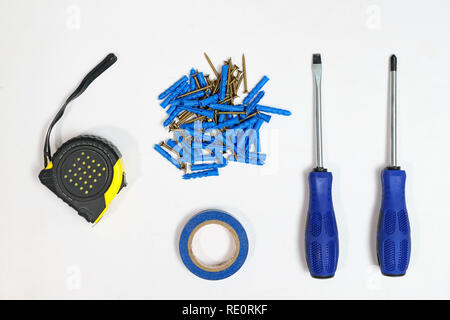 Top view of tape measure and blue screwdrivers with heap of nails on white background Stock Photo