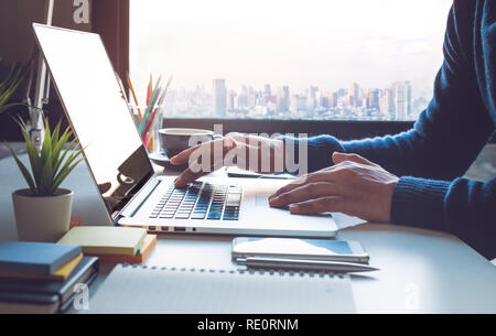 Young businessman working on laptop in office with window city view.Business strategic planning.study learning,blogger and freelance concepts ideas -  Stock Photo