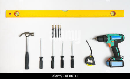 Top view of screwdrivers,hammer, screws, dowels amd ruler on white backdrop. Stock Photo