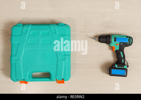 Top view of blue plastic case and electric drill on wooden background Stock Photo