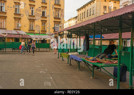 Krakow, Poland - July 10th 2018. A market stall holder in Plac Nowy awaits the final few customers at the end of the day before packing up Stock Photo