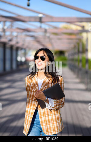 Fashionable Asian woman with laptop outdoors portrait Stock Photo