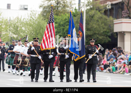 Louisville, Kentucky, USA - May 03, 2018: The Pegasus Parade, Firefighters carrying axes, scorting the American flag Stock Photo