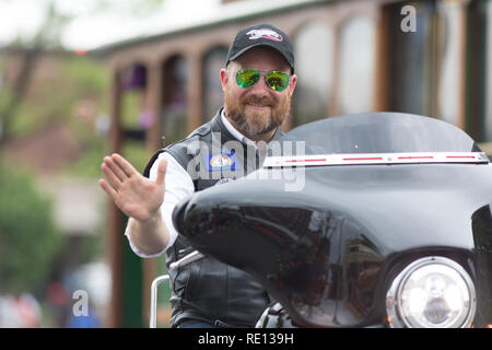 Louisville, Kentucky, USA - May 03, 2018: The Pegasus Parade, Man riding motorcycle waving for the camera Stock Photo