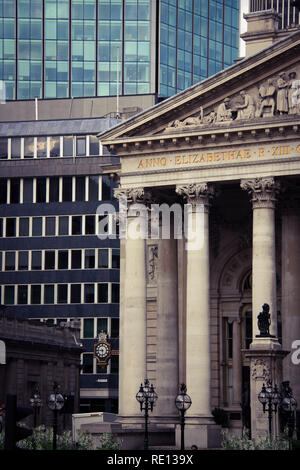 Columns of the Royal Exchange with the glass facade of the Royal Bank of Scotland building and the Stock Exchange Tower in the background - London, UK