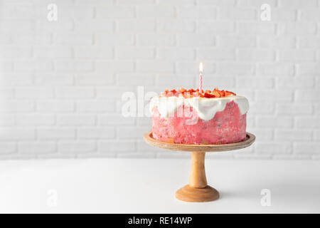 Strawberry cake with one burning candle on white Stock Photo