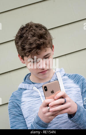 Teenage boy texting on his new Apple iPhone X Stock Photo