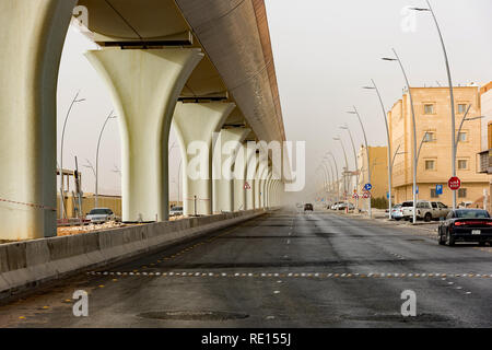 Riyadh Metro elevated rail disappearing into the distance during morning dust storm Stock Photo
