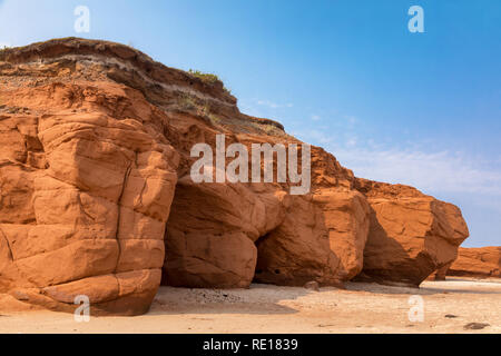 The red cliffs and beach of  Havre aux Maisons, on the Gulf of St Lawrence, Iles de la Madeleine, Canada. Blue sky background and space for text. Stock Photo