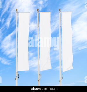 Three blank white flags on flagpoles against cloudy blue sky, corporate flag mockup to ad logo, text or symbol, company identity flag template Stock Photo