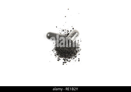Opened activated charcoal capsule also known as activated carbon as medical drug isolated on white. Stock Photo