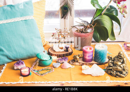 Feng Shui altar at home in living room or bed room. Attracting wealth and prosperity concept. Crystal clusters, wire tree with gemstones, golden Budda Stock Photo