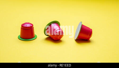 Coffee capsules compostable. Red espresso pods, eco friendly, aluminum free with green ring on yellow background Stock Photo