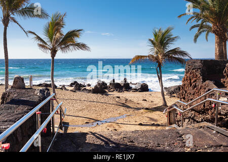 Puerto del Carmen beach in Lanzarote, Canary islands, Spain. blue sea, palm trees, selective focus