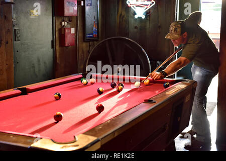 Young man playing pool in saloon bar Stock Photo