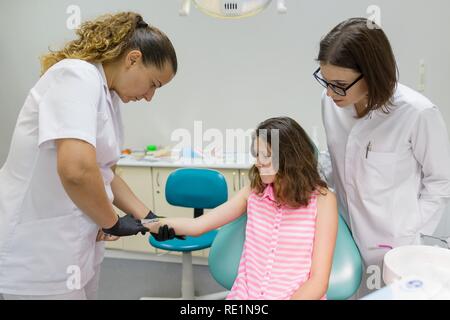 Dentist makes an injection in the hand, checks the reaction of the body to anesthetic preparations. Stock Photo