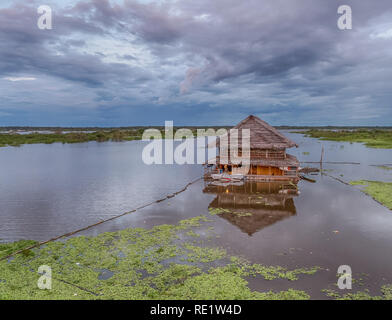 Iquitos, Peru- March 29, 2018: View of a floating house and the Itaya river in the center of Iquitos, Loreto, Peru.  Amazon Stock Photo