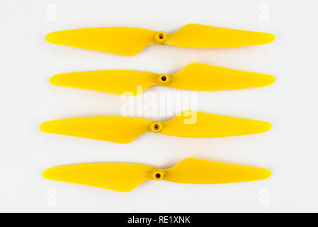 Yellow, plastic propellers for a quadcopter drone, isolated on white background with clipping path. Four pieces arranged in a row. Stock Photo