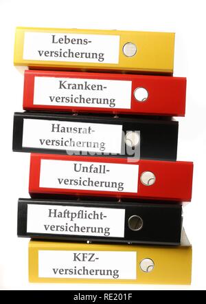 Black, yellow and red ring binders, labelled in German for life insurance, health insurance, household insurance Stock Photo