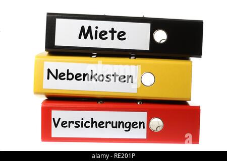 Black, yellow and red ring binders, labelled in German for rent, utilities and insurance Stock Photo