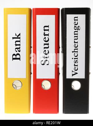 Black, yellow and red ring binders, labelled in German for banking, taxes and insurance Stock Photo