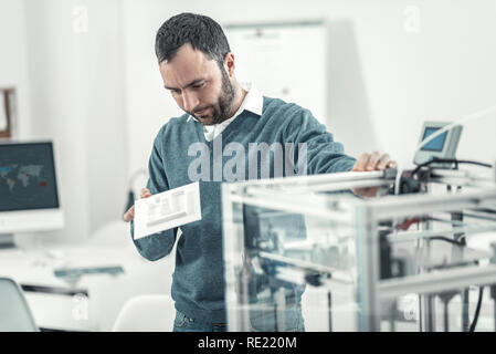 Smart serious adult man reading the instruction Stock Photo