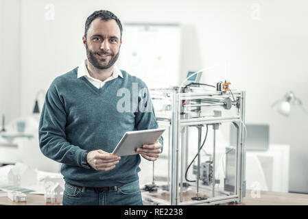Delighted positive man standing in the office Stock Photo