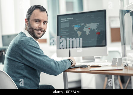 Positive handsome nice man working on his laptop Stock Photo