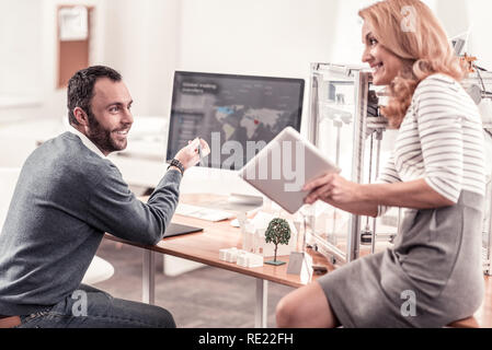Smart smiling colleagues discussing their new idea Stock Photo