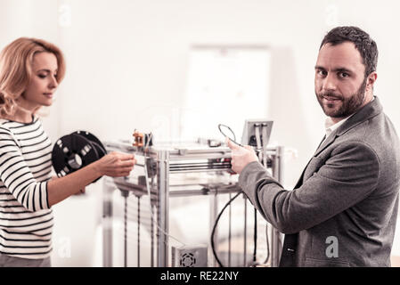 Intelligent technicians fixing and adjusting office equipment Stock Photo