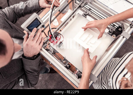 Top view of man adjusting 3D printer Stock Photo