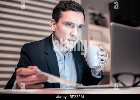 Serious nice man looking at the computer screen Stock Photo
